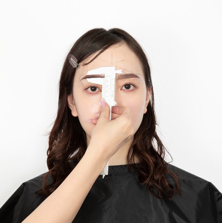 A brow measured against the golden ratio with a caliper during a Fortunebrows diagnosis